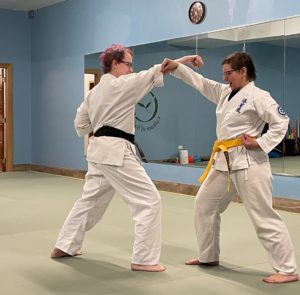 A student demonstrates a technique with an instructor
